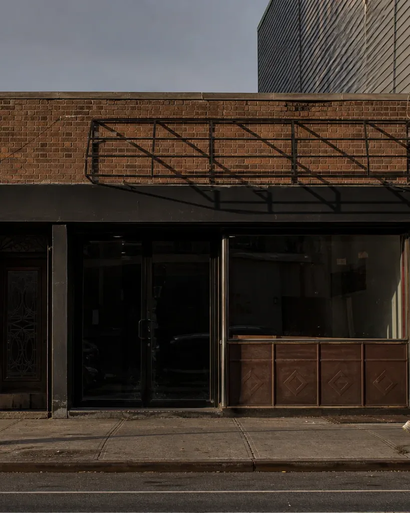 A low-rise brick commercial storefront on a Brooklyn mixed-use street